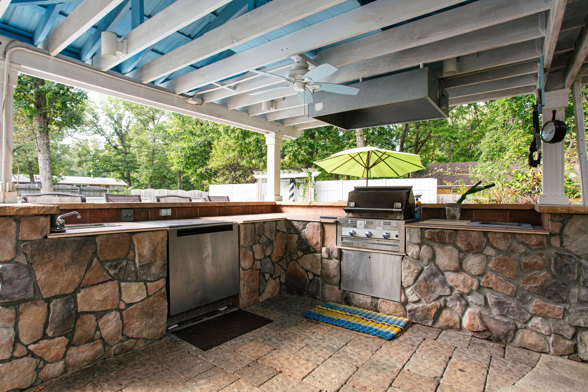 Outdoor Kitchen With Stone Countertops And Appliances.